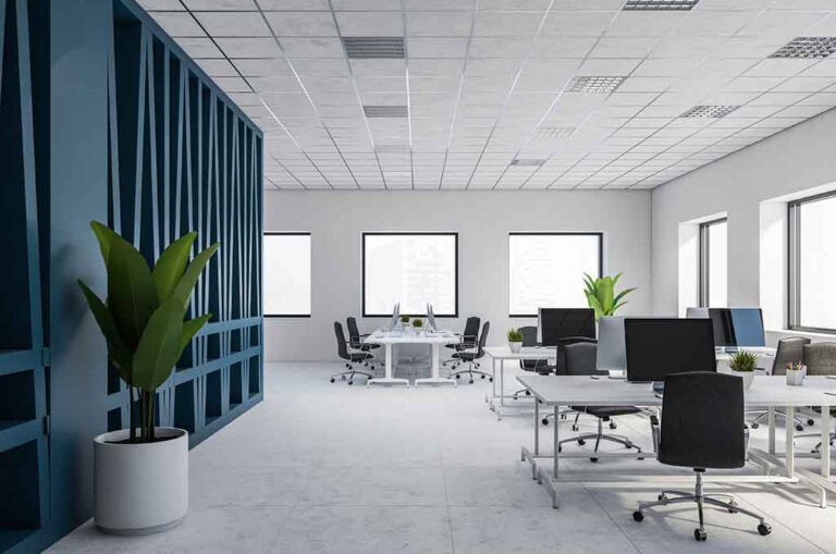 Ett tomt kontor med blå väggar och vita skrivbord i Norrköping.