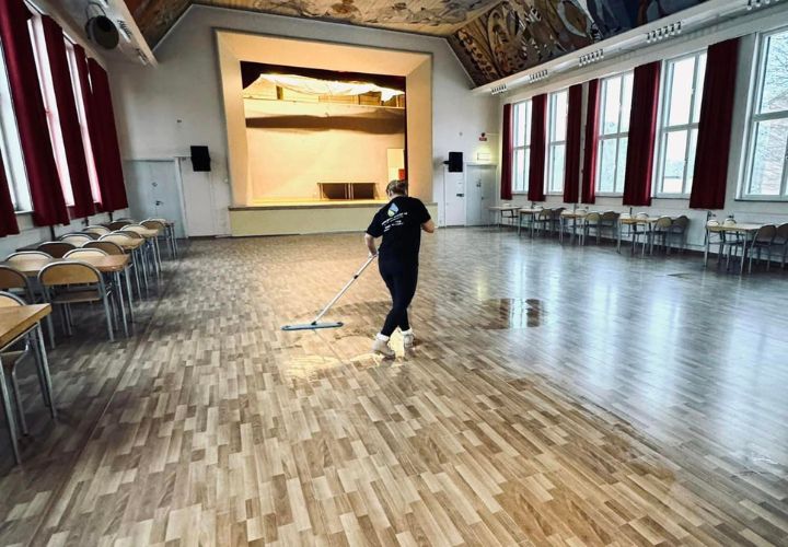 En person från Allstäd, en Norrköpingsbaserad städfirma, torkar golvet.