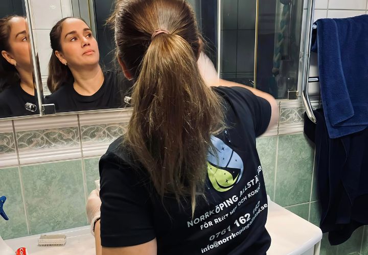 En kvinna som beundrar sin reflektion i en spegel medan hon gör sig redo för dagen.